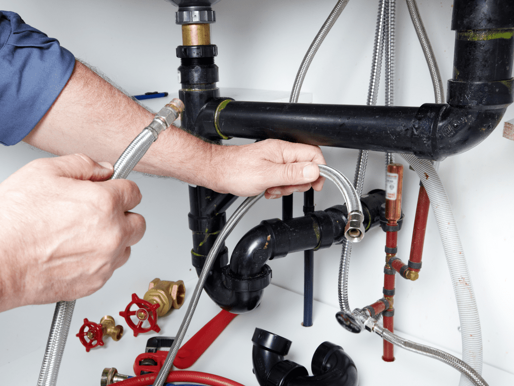 plumber working under a sink.