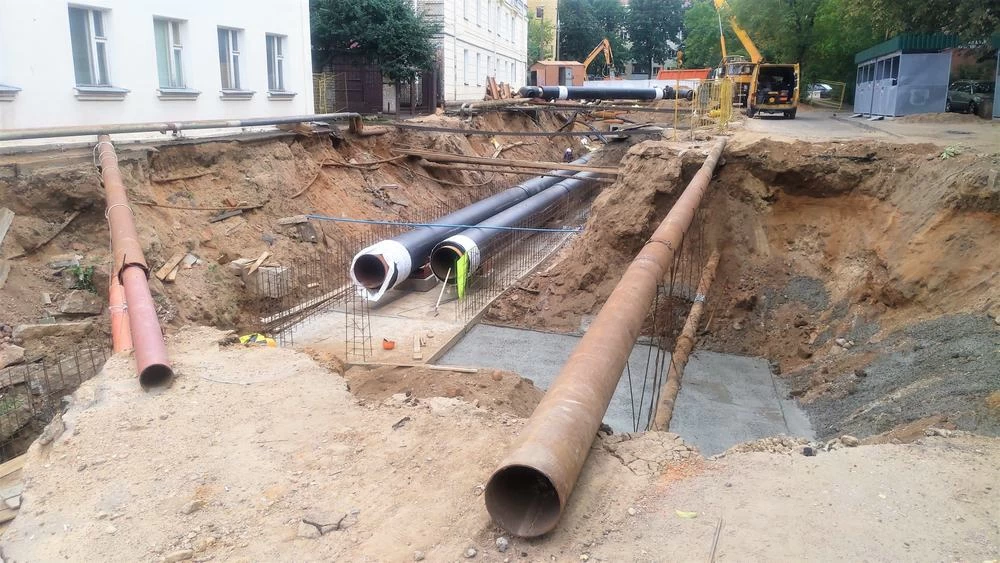 A hole dug on a city street for underground utility repair or pipe maintenance work