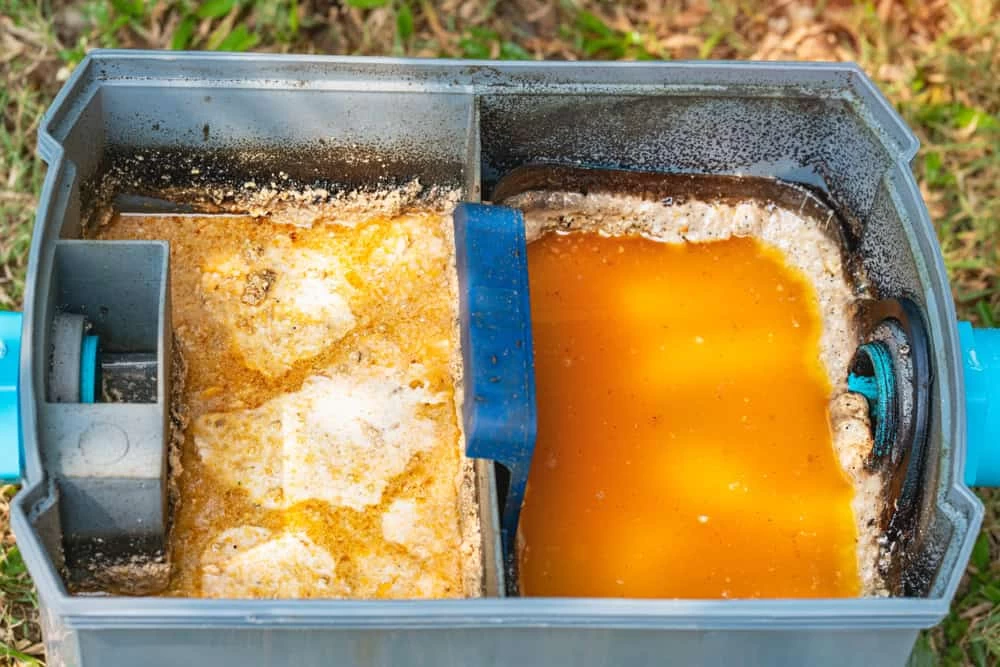 Grease trap connected to wastewater treatment ponds for proper disposal