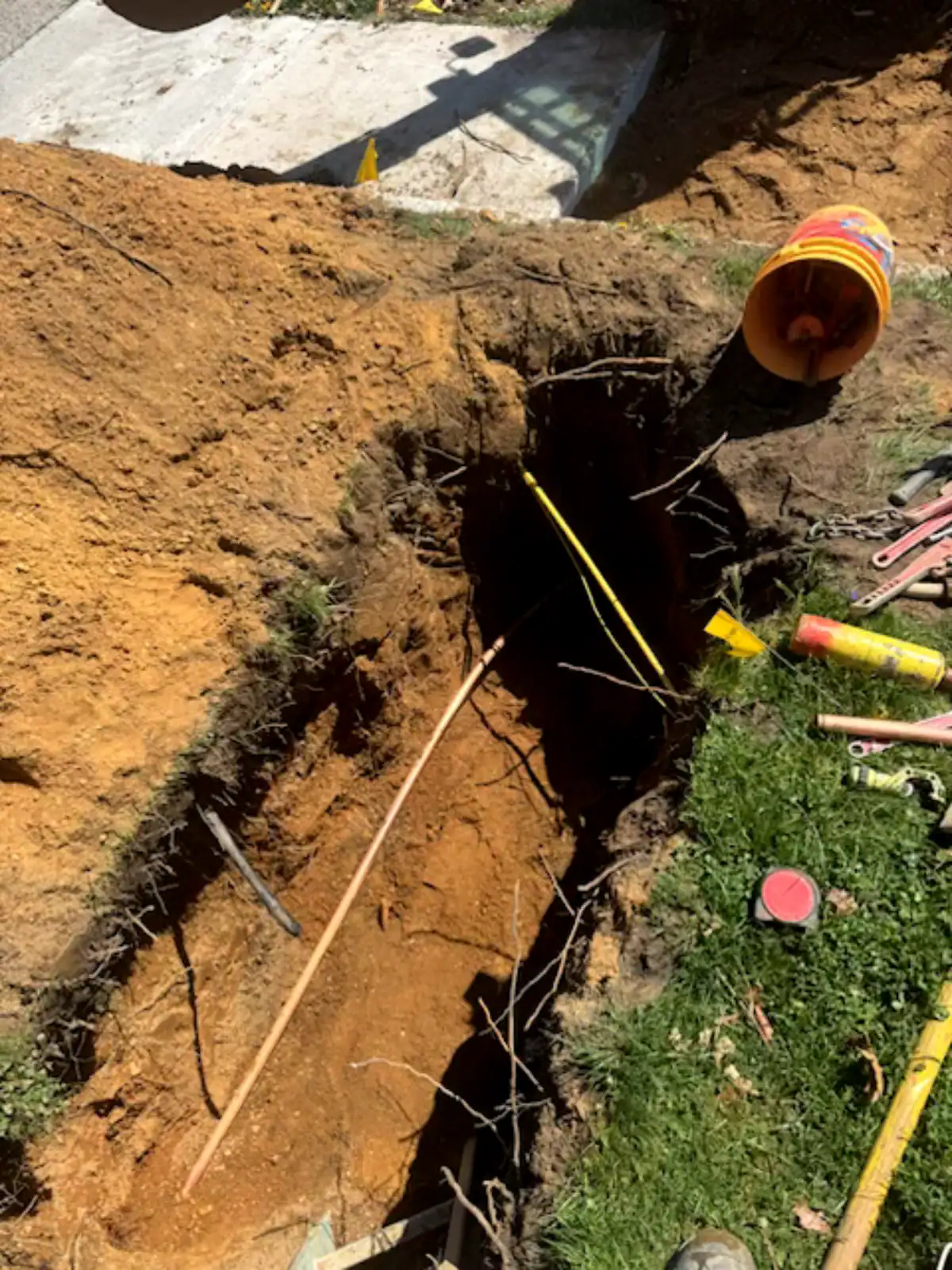 Trenchless plumbing technology in action on Long Island, NY, showcasing a ground opening for seamless sewer and water line replacement. The image features specialized equipment and technicians working efficiently to install new pipes without extensive digging
