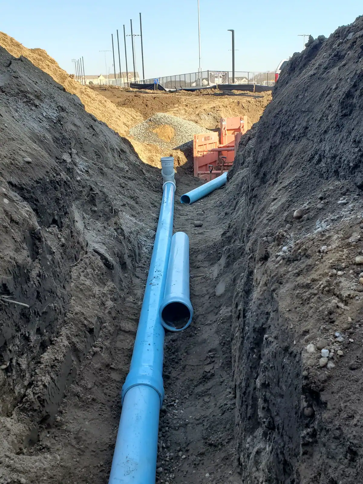 Light blue trenchless plumbing pipe being installed underground with excavation equipment on Long Island, NY