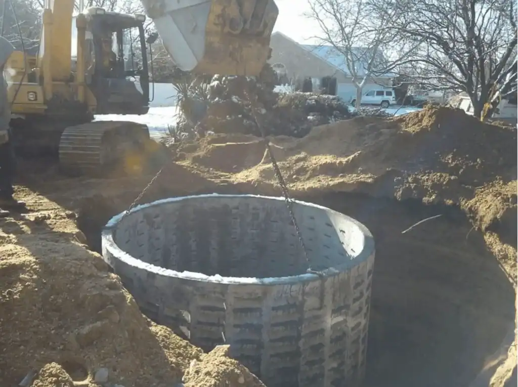 Excavation work at a construction site in Nassau County, NY, showing heavy machinery digging and clearing earth, with construction materials and safety barriers visible on site.